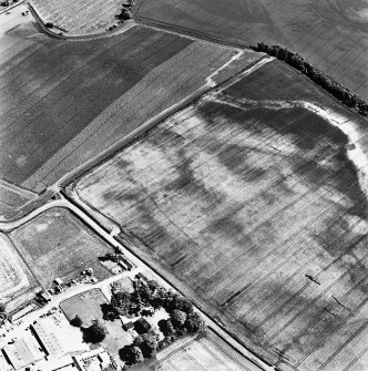 Preston Mains, oblique aerial view, taken from the NW, centred on the cropmarks of a possible cursus monument and enclosure. A linear cropmark is visible in the bottom right-hand corner of the photograph.