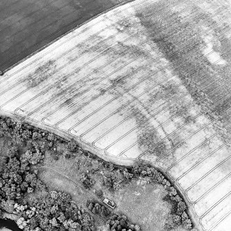 Oblique aerial view centred on the cropmarks of the fort, taken from the E.