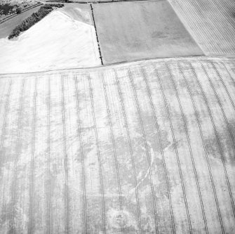 Oblique aerial view centred on the cropmarks of the fort and pit-alignment with the settlement adjacent, taken from the WSW.