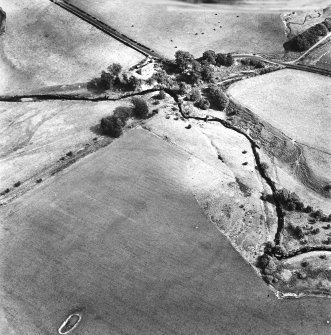 Cappuck, oblique aerial view, taken from the ESE, centred on the cropmark of an enclosure. The site of a Roman Fort is shown in the top right-hand side of the photograph.