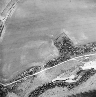 Oblique aerial view centred on the cropmarks of the fort, linear cropmark and cropmarks of the building, taken from the SSE.