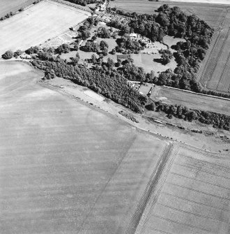 Oblique aerial view centred on the cropmarks of the settlement with the country house adjacent, taken from the WNW.