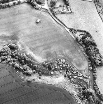 Oblique aerial view centred on the cropmarks of the enclosure with dovecot adjacent, taken from the ENE.