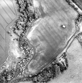 Oblique aerial view centred on the cropmarks of the enclosure with dovecot adjacent, taken from the NNW.
