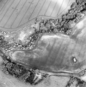 Oblique aerial view centred on the cropmarks of the enclosure with dovecot adjacent, taken from the WNW.