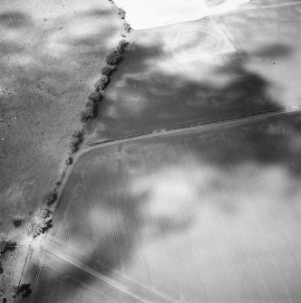 Oblique aerial view centred on the cropmarks of the rectilinear settlement and other cropmarks with the timber halls and enclosure and the cropmarks of the possible enclosure adjacent, taken from the S.