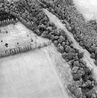 Oblique aerial view of Whittingehame Castle centred on the cropmarks of a fort, taken from the SW.