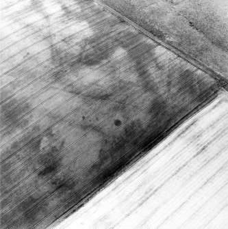 Oblique aerial view centred on the cropmarks of the linear cropmarks, pits and possible roundhouse, taken from the ESE.