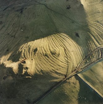 Oblique aerial view centred on the remains of rig, cairn and quarry, taken from the N.