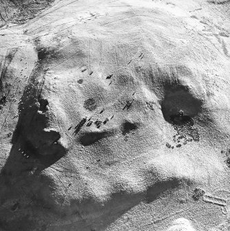 Oblique aerial view centred on the remains of the cord rig with building and enclosures adjacent, taken from the NNE.