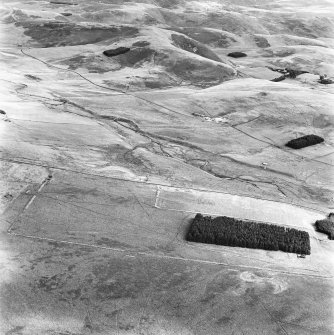 Pennymuir, oblique aerial view, taken from the WSW, centred on three Roman Temporary Camps, a linear earthwork and an area of rig. The course of 'Dere Street' is shown in the centre of the photograph.