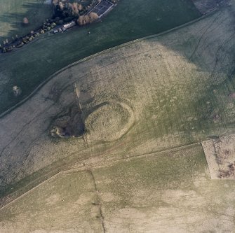 Oblique aerial view centred on the remains of the fort and quarry, taken from the NW.