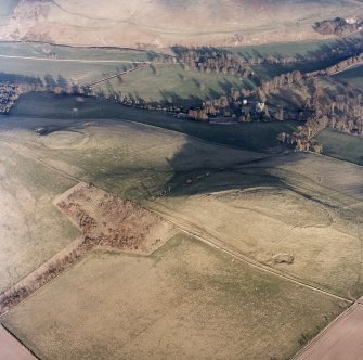 Oblique aerial view centred on the remains of the fort and settlement with fort adjacent, taken from the WNW.