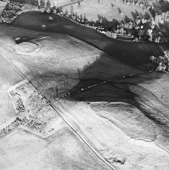 Oblique aerial view centred on the remains of the fort and settlement with fort adjacent, taken from the WSW.