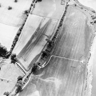 Wooden Home Farm Roman temporary camp, oblique aerial view, taken from the NNE, showing the NE angle in the top centre of the photograph. Cropmarks including those of pits are visible in the centre.