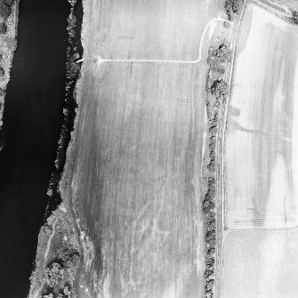 Wooden Home Farm Roman temporary camp, oblique aerial view, taken from the SW, showing the NE angle in the centre right of the photograph. Cropmarks including those of pits are visible in the centre right.