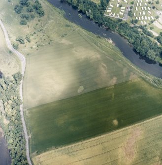 Oblique aerial view centred on the linear cropmarks and cropmarks with the remains of the castle and the cauld adjacent, taken from the SW.