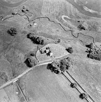 Oblique aerial view centred on the church and burial ground, taken from the W.