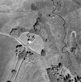 Oblique aerial view centred on the church and burial ground, taken from the SW.