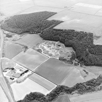 Oblique aerial view centred on the quarry and the remains of the earthwork, taken from the N.