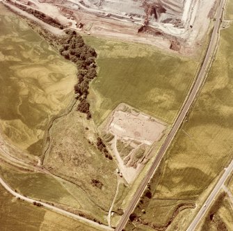 Oblique aerial view showing the excavation of a palisaded enclosure.