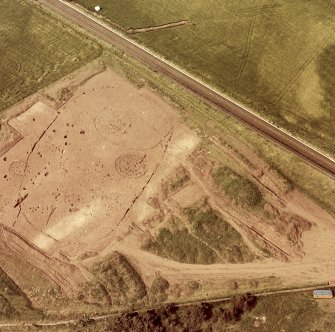 Oblique aerial view showing the excavation of a palisaded enclosure.