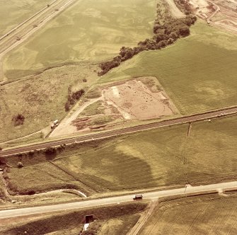 Oblique aerial view showing the excavation of a palisaded enclosure.