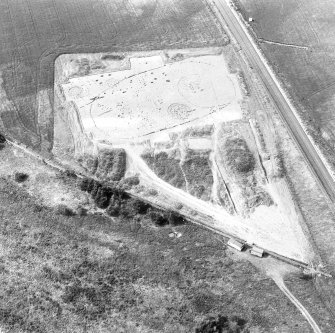 Oblique aerial view showing the excavation of a palisaded enclosure.