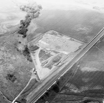 Oblique aerial view showing the excavation of a palisaded enclosure.