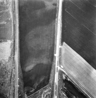 Oblique aerial view showing the cropmark of a palisaded enclosure (2) part of the excavation of a palisaded enclosure (1).