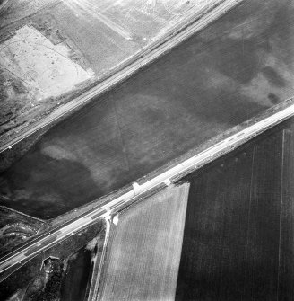 Oblique aerial view showing the cropmark of a palisaded enclosure (2) part of the excavation of a palisaded enclosure (1).