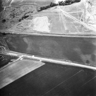 Oblique aerial view showing the cropmark of a palisaded enclosure (2) andfthe excavation of a palisaded enclosure (1).