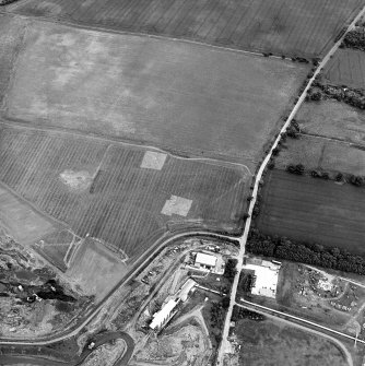 Oblique aerial view centred on the trial excavations with the cement works and quarry adjacent, taken from the W.
