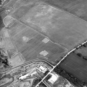 Oblique aerial view centred on the trial excavations with the cement works and quarry adjacent, taken from the WSW.