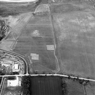 Oblique aerial view centred on the trial excavations with the cement works and quarry adjacent, taken from the SSW.
