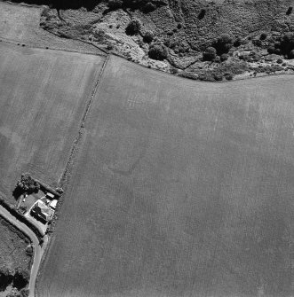 Oblique aerial view of Thornton Law centred on the cropmark of an enclosure.  Taken from the SSE.