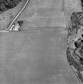 Oblique aerial view of Thornton Law centred on the cropmark of an enclosure.  Taken from the WNW.