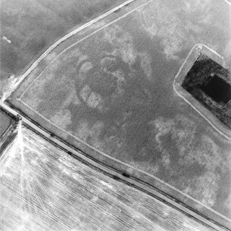 Oblique aerial view centred on the cropmarks of the settlement with settlement adjacent, taken from the ESE.