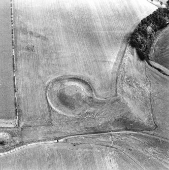 Oblique aerial view centred on the remains of the motte-and-bailey castle, taken from the NNW.