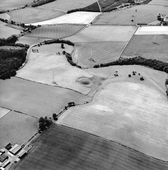Oblique aerial view centred on the remains of the motte-and-bailey castle with the remains of the country house adjacent, taken from the NNE.