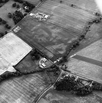 Edrom Manse, oblique aerial view, taken from the W, centred on the cropmarks of an enclosure. Edrom Newton farm buildings are visible in the top left-hand corner of the photograph.