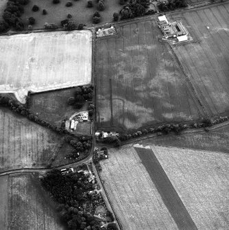 Edrom Manse, oblique aerial view, taken from the NNE, centred on the cropmarks of an enclosure. Edrom Newton farm buildings are visible in the top right-hand corner of the photograph.