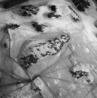 Oblique aerial view centred on the settlement and farmstead with the settlement and enclosure adjacent, taken from the SW.