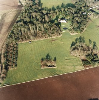 Oblique aerial view centred on the deserted medieval village, bastle, church and burial ground, with remains of the rig, possible enclosures, country house and walled garden adjacent, taken from the SSW.