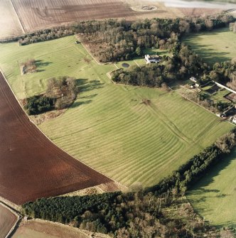 Oblique aerial view of the remains of the rig and possible enclosures with remains of the deserted medieval village, bastle, church, burial ground, country house and walled garden adjacent, taken from the SE.
