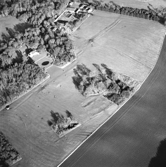 Oblique aerial view centred on the deserted medieval village, bastle, church and burial ground, with remains of the rig, possible enclosures, country house and walled garden adjacent, taken from the SW.