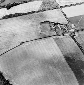 Oblique aerial view centred on the cropmarks of the enclosure, field boundaries, possible enclosures and linear cropmarks with farmhouse and farmsteading adjacent, taken from the S.