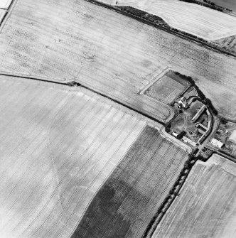 Oblique aerial view centred on the cropmarks of the enclosure, field boundaries, possible enclosures and linear cropmarks with farmhouse and farmsteading adjacent, taken from the SE.