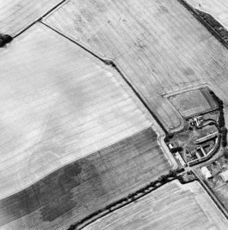 Oblique aerial view centred on the cropmarks of the enclosure, field boundaries, possible enclosures and linear cropmarks with farmhouse and farmsteading adjacent, taken from the E.