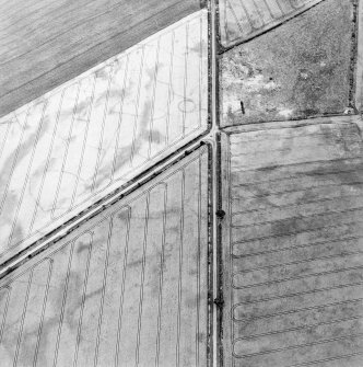 Oblique aerial view centred on the cropmarks of the barrow and ring-ditch, taken from the WNW.